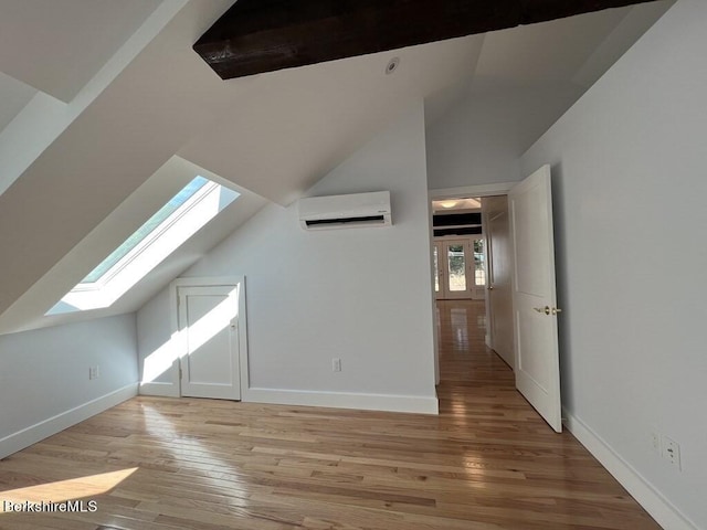 bonus room with a wall mounted air conditioner, lofted ceiling with skylight, and light hardwood / wood-style flooring