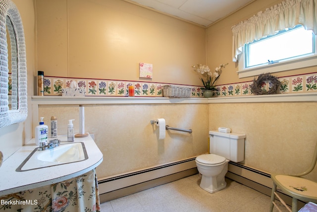 bathroom featuring toilet, baseboard heating, and sink