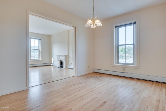 36 Holden St Unit A, North Adams, MA 01247 - spare room featuring baseboard heating, a chandelier, wood finished floors, and a baseboard radiator