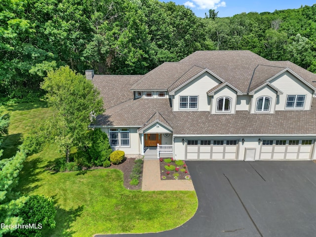 view of front of house featuring a front yard, a porch, and a garage