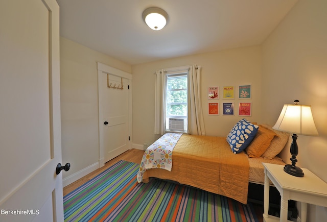 bedroom featuring hardwood / wood-style flooring and cooling unit