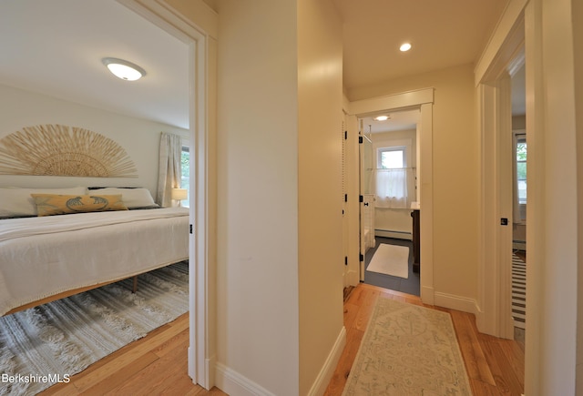 corridor with light hardwood / wood-style flooring and a baseboard radiator