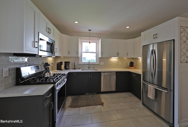 kitchen with white cabinets, decorative light fixtures, stainless steel appliances, and sink