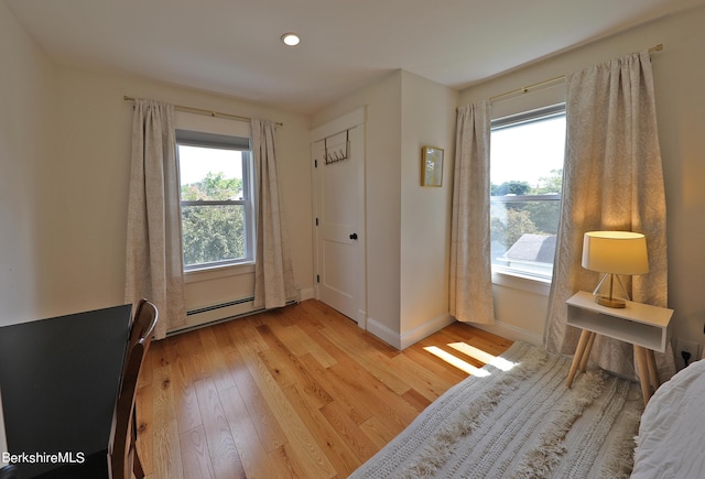 doorway to outside with light wood-type flooring and a baseboard radiator