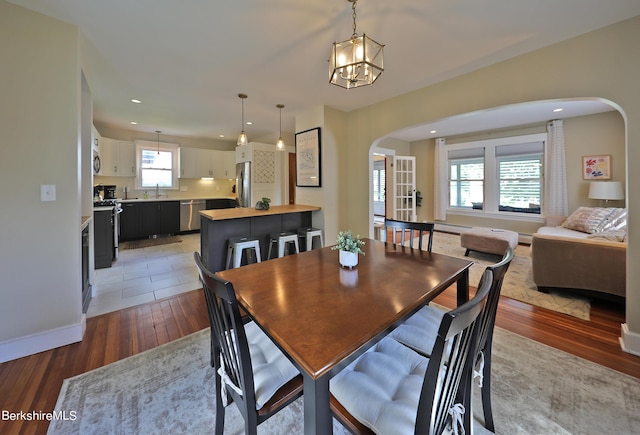 dining space with dark hardwood / wood-style flooring, a chandelier, plenty of natural light, and sink