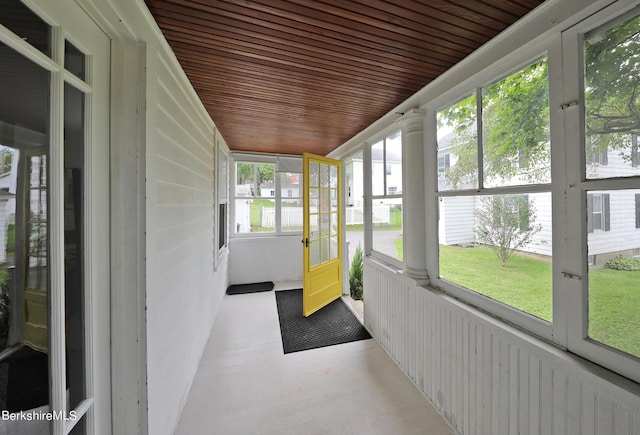 unfurnished sunroom featuring plenty of natural light and wooden ceiling