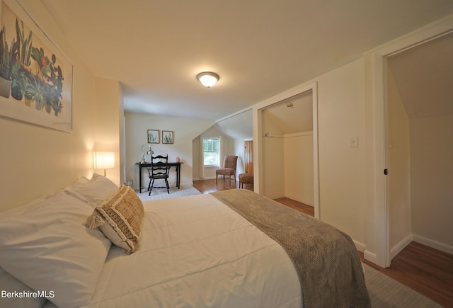 bedroom featuring wood-type flooring and vaulted ceiling