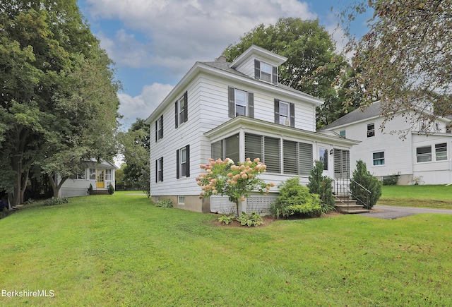 view of front facade featuring a sunroom and a front yard