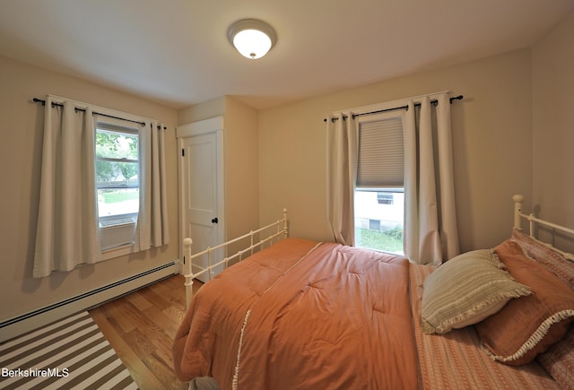 bedroom featuring wood-type flooring and a baseboard radiator