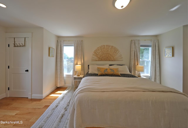 bedroom featuring light hardwood / wood-style flooring and multiple windows