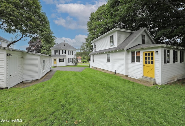 back of property featuring a yard