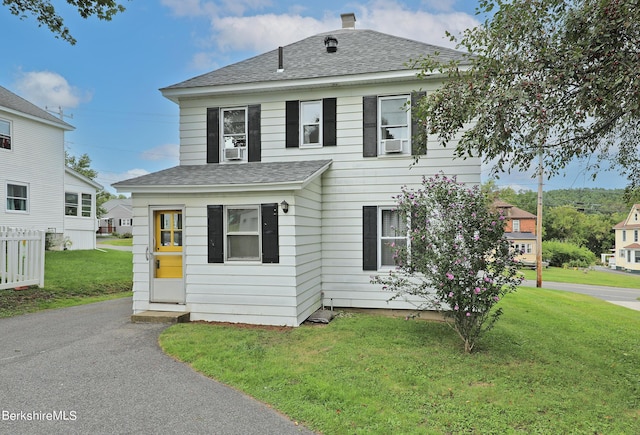 view of front of house with cooling unit and a front yard