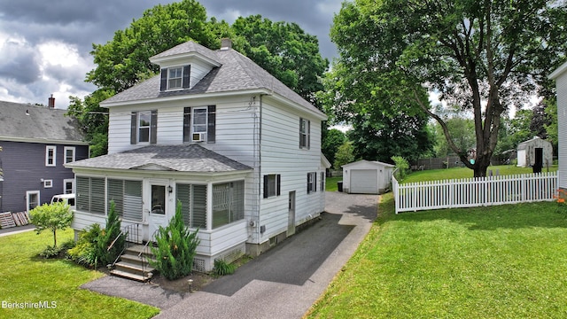 view of front facade featuring an outbuilding, a front lawn, and a garage