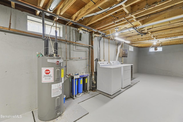 basement featuring independent washer and dryer, a healthy amount of sunlight, and electric water heater