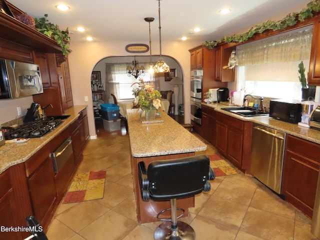 94 Gale Ave, Pittsfield, MA 01201 - kitchen with stainless steel appliances, arched walkways, a kitchen island, a warming drawer, and light stone counters