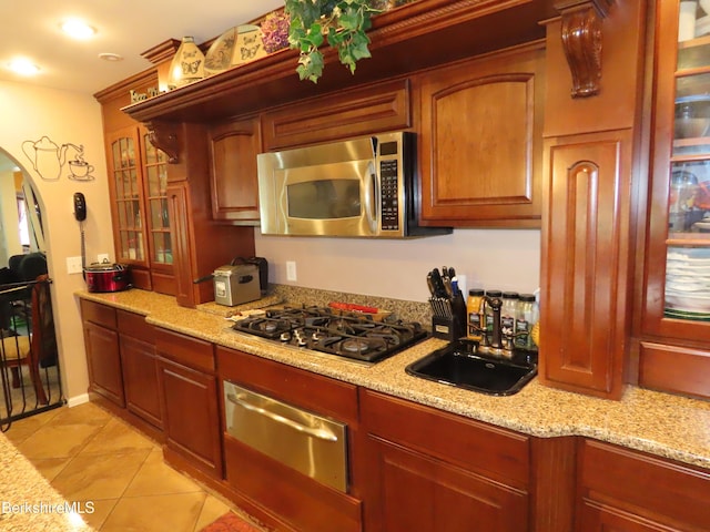 94 Gale Ave, Pittsfield, MA 01201 - kitchen with stainless steel microwave, a warming drawer, gas stovetop, arched walkways, and light tile patterned floors