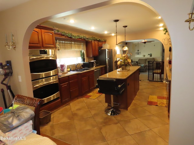 94 Gale Ave, Pittsfield, MA 01201 - kitchen with appliances with stainless steel finishes, arched walkways, a kitchen island, pendant lighting, and light stone counters