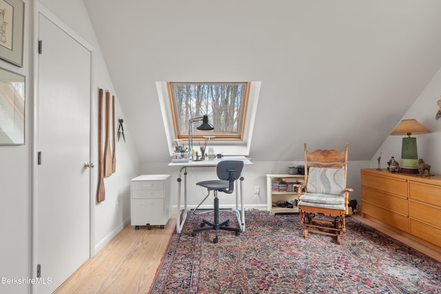 home office with light wood-style floors, baseboards, and vaulted ceiling