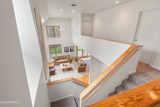 stairs featuring recessed lighting, a ceiling fan, a high ceiling, and visible vents