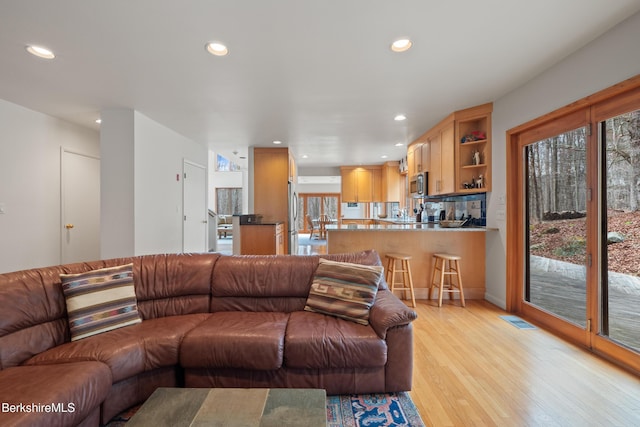 living area featuring light wood-type flooring, recessed lighting, and visible vents