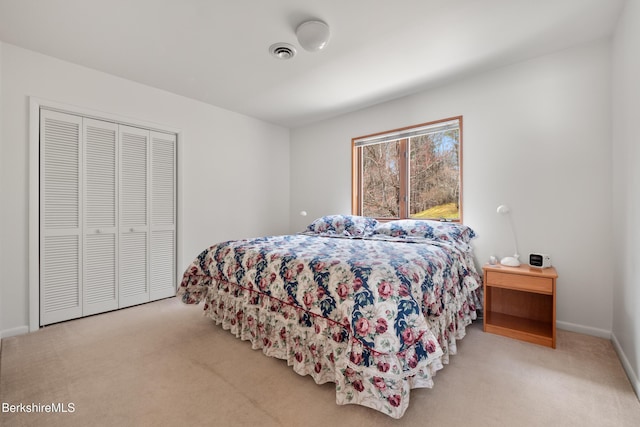 bedroom with visible vents, carpet flooring, baseboards, and a closet