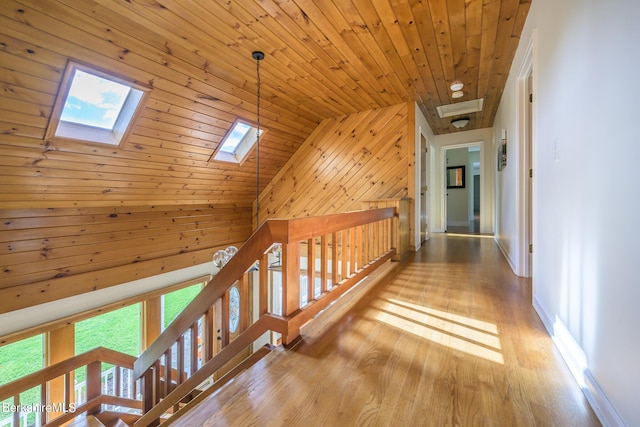 hall with vaulted ceiling with skylight, wooden ceiling, and light wood-type flooring