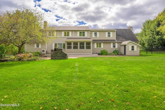 rear view of house featuring a lawn and a sunroom