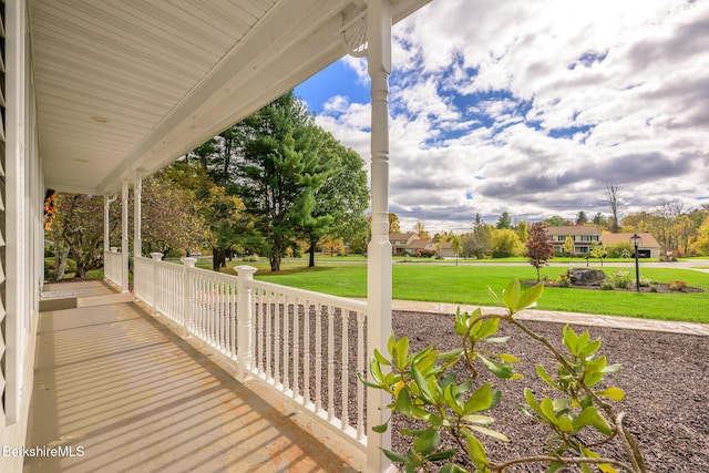 deck featuring covered porch and a yard