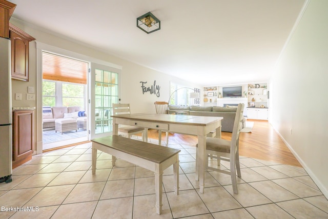 dining room with built in features, ornamental molding, and light tile patterned floors