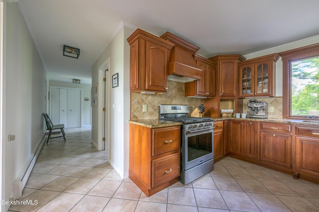 kitchen with gas range, stone counters, a baseboard radiator, backsplash, and light tile patterned floors