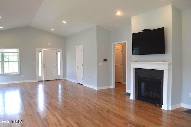 unfurnished living room featuring light hardwood / wood-style flooring and vaulted ceiling