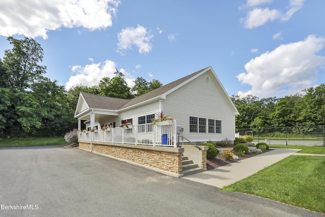 view of front of property featuring covered porch and a front lawn