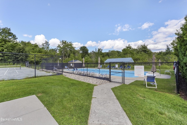 view of pool with a yard and tennis court