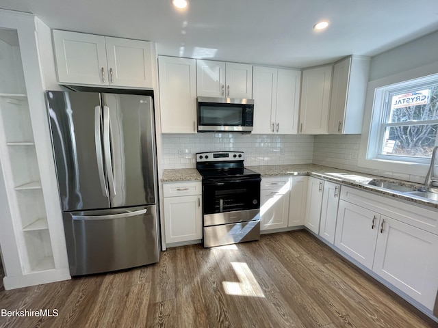 kitchen featuring a sink, stainless steel appliances, dark wood-style flooring, and white cabinetry