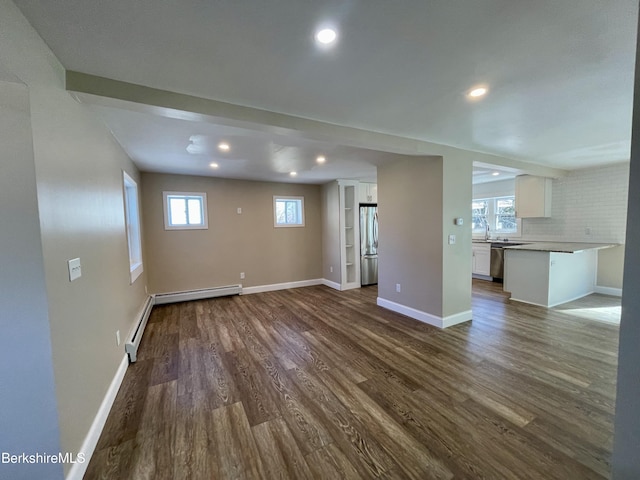 unfurnished living room with recessed lighting, dark wood-type flooring, and baseboards