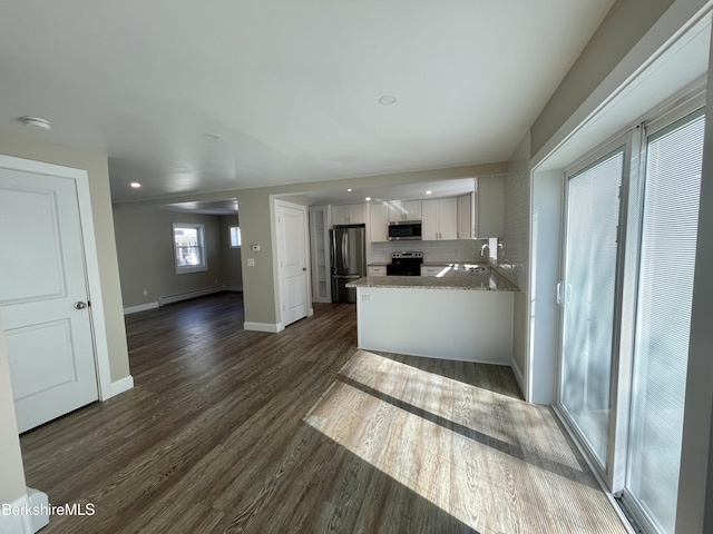 kitchen featuring a baseboard radiator, dark wood-style flooring, stainless steel appliances, decorative backsplash, and white cabinetry