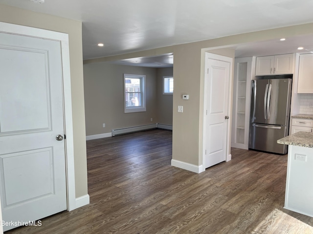 kitchen with a baseboard heating unit, tasteful backsplash, dark wood-style floors, freestanding refrigerator, and white cabinets