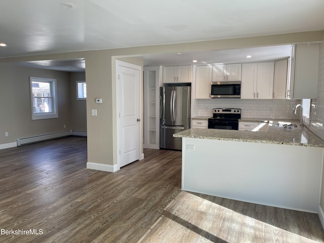 kitchen featuring light stone countertops, a baseboard radiator, stainless steel appliances, white cabinetry, and dark wood-style flooring