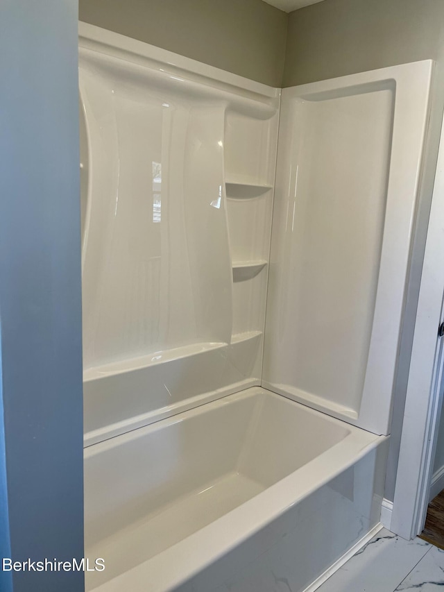 full bath featuring marble finish floor and a shower