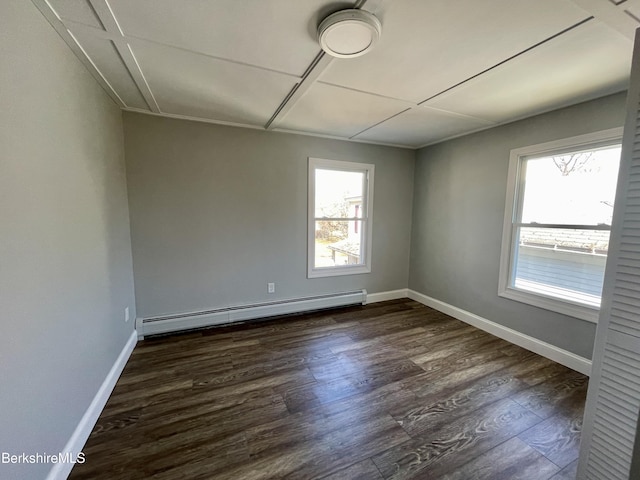 unfurnished room with dark wood-type flooring, attic access, baseboards, and baseboard heating