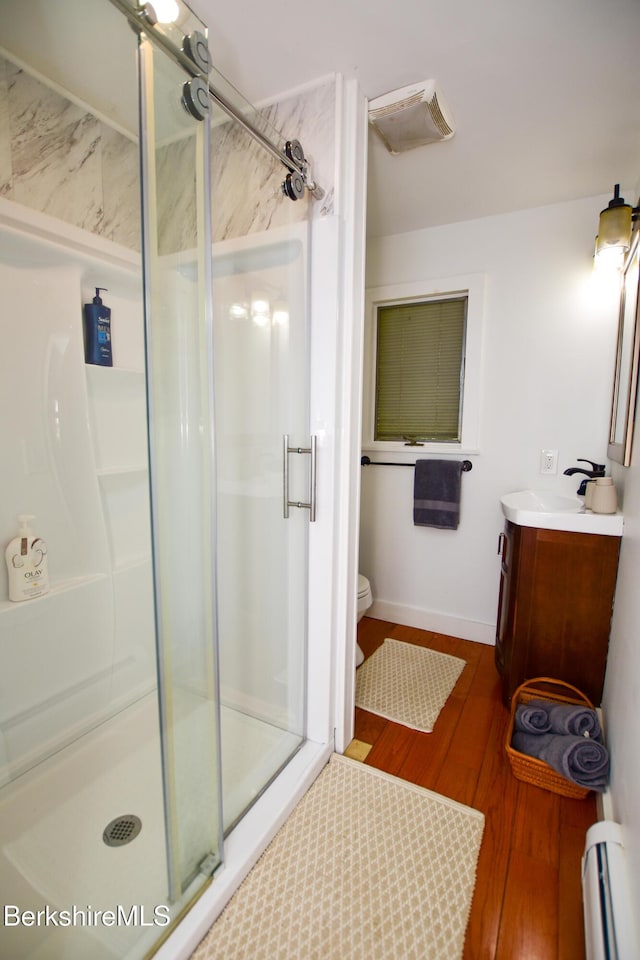 162 Ymca Rd, Becket, MA 01223 - full bathroom with baseboard heating, vanity, a stall shower, toilet, and wood finished floors