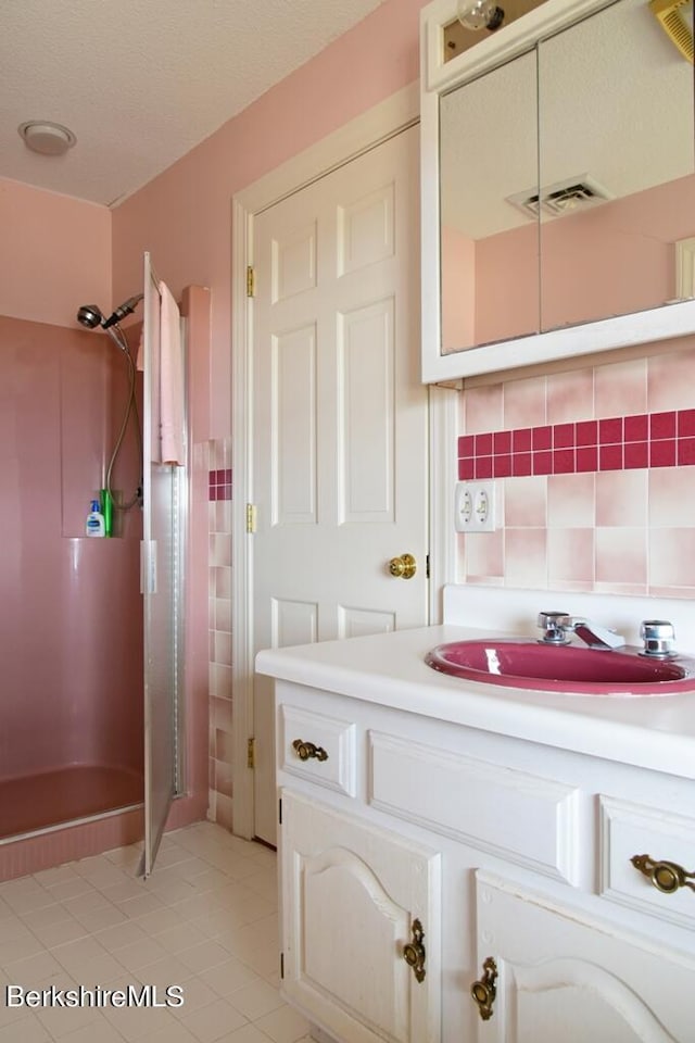 bathroom with decorative backsplash, a shower, vanity, and tile patterned floors