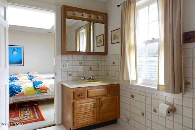 bathroom with vanity, tasteful backsplash, and a wealth of natural light