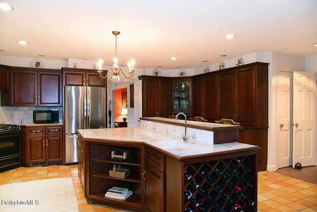 kitchen featuring pendant lighting, sink, light tile patterned floors, and black appliances