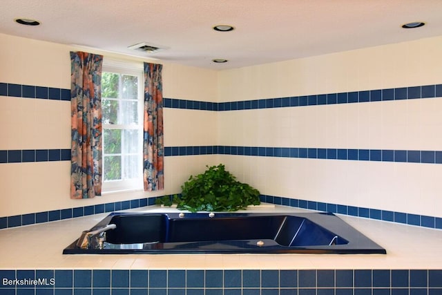 bathroom with a relaxing tiled tub