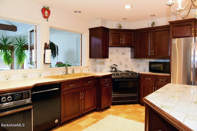 kitchen with tile countertops, black appliances, sink, decorative backsplash, and light tile patterned floors