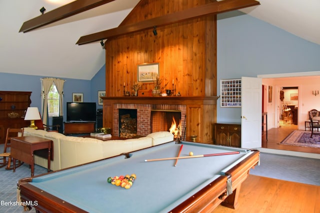 game room with hardwood / wood-style floors, vaulted ceiling with beams, a fireplace, and billiards