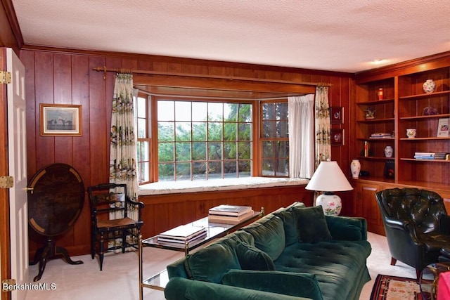 carpeted living room featuring a textured ceiling and wooden walls