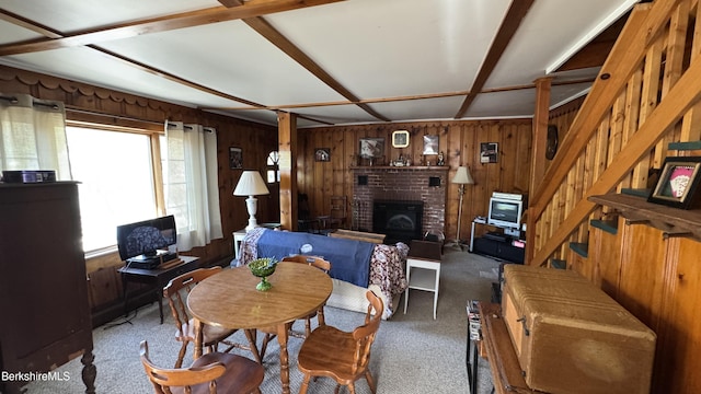 dining area with carpet, stairs, and wood walls