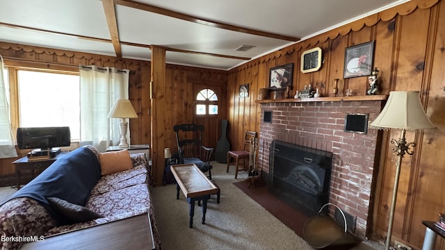 carpeted living area with visible vents, wood walls, and a brick fireplace